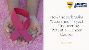 Hands holding a pink cancer awareness ribbon beside text reading “How the Nebraska Watershed Project Is Uncovering Potential Cancer Causes,” representing pediatric cancer research and awareness